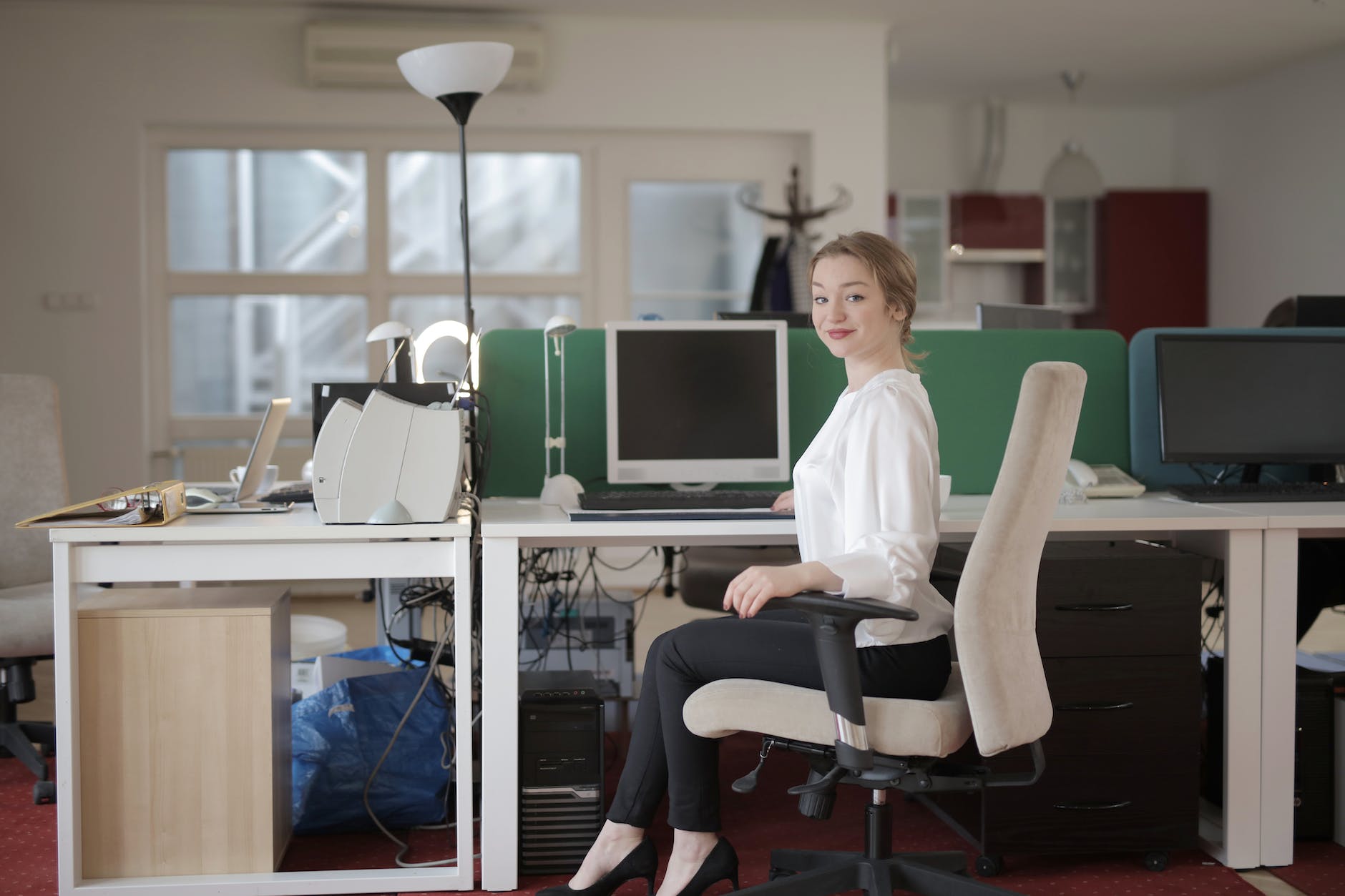 elegant female employee sitting on chair in modern workplace as Virtual assistant
